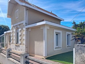 Ein zweistöckiges Gebäude mit Flachdach, Balkon und kleinem Fenster.