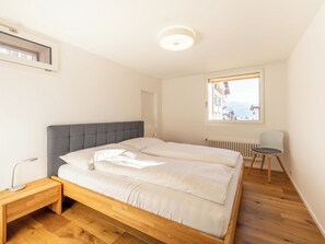 Makuuhuoneessa on sänky, yöpöytä, tuoli, ikkuna, josta on näkymä, ja patteri.