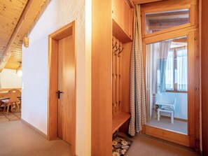 Ein Holzinnenraum mit einer Tür, einer Bank und einer Glastür, die auf einen Balkon führt.