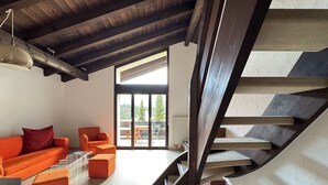 Ein modernes Interieur mit einer Holztreppe, einer Couch und einem Essbereich mit Blick.