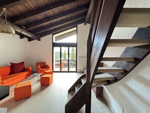 Ein modernes Interieur mit einer Holztreppe, einer Couch und einem Essbereich mit Blick.