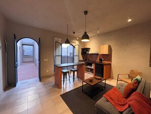 Ein kompakter Wohnraum mit Küchenzeile, Essbereich und Sofa.