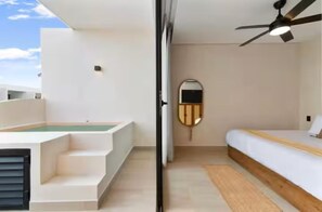 A modern hotel room with a bed, a ceiling fan, a small window, and a view of the sky. - Premium Penthouse with Luxury Amenities (Q.R.)