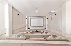A modern cinema room with a large screen, reclining seats, and a minimalist design. - Premium Penthouse with Luxury Amenities (Q.R.)