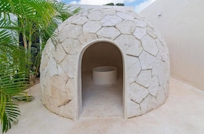 A stone structure with an arched entrance, possibly a restroom or a small shelter. - Premium Penthouse with Luxury Amenities (Q.R.)