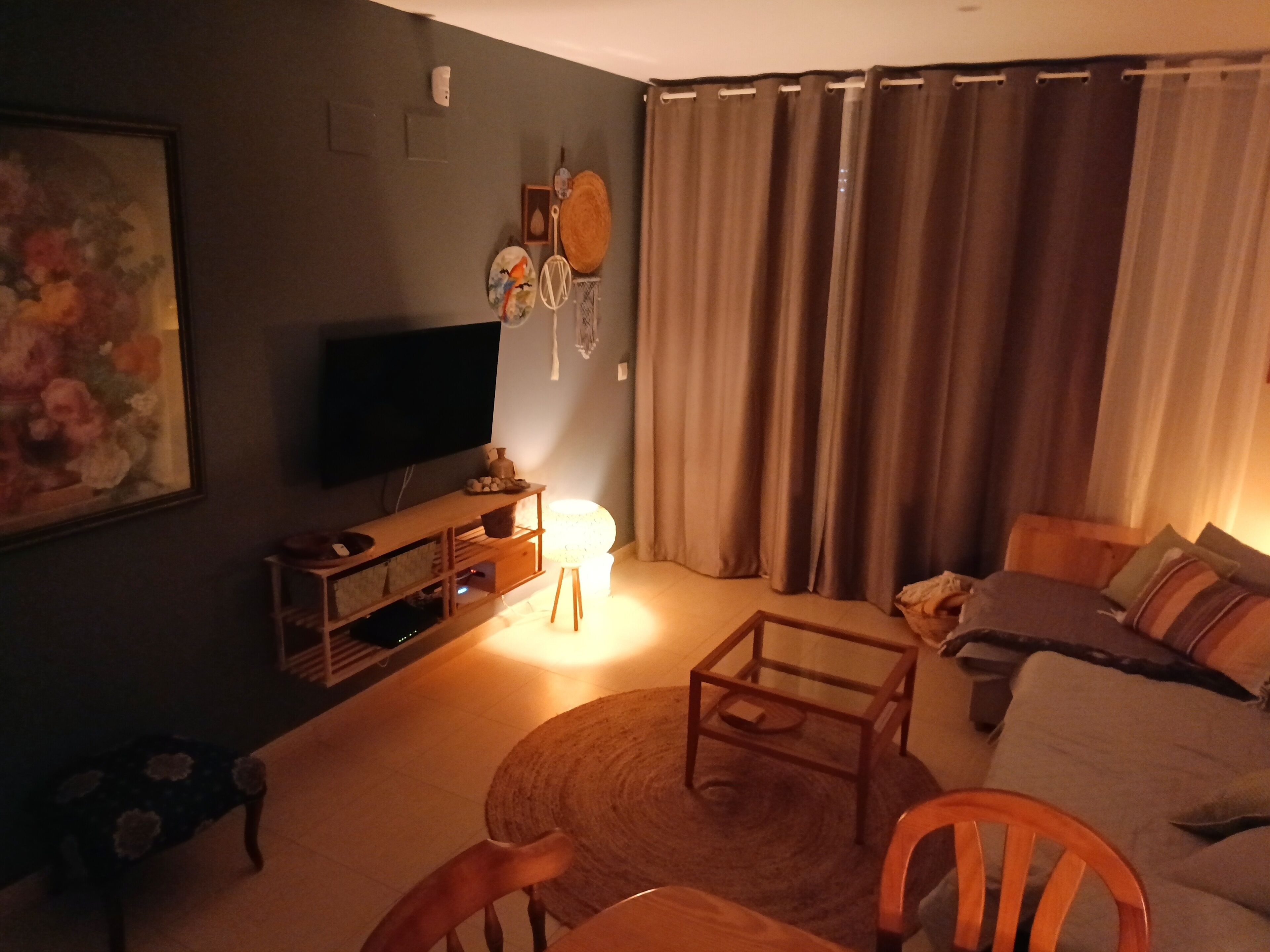 A living room with a television, a sofa, a coffee table, and a chair.