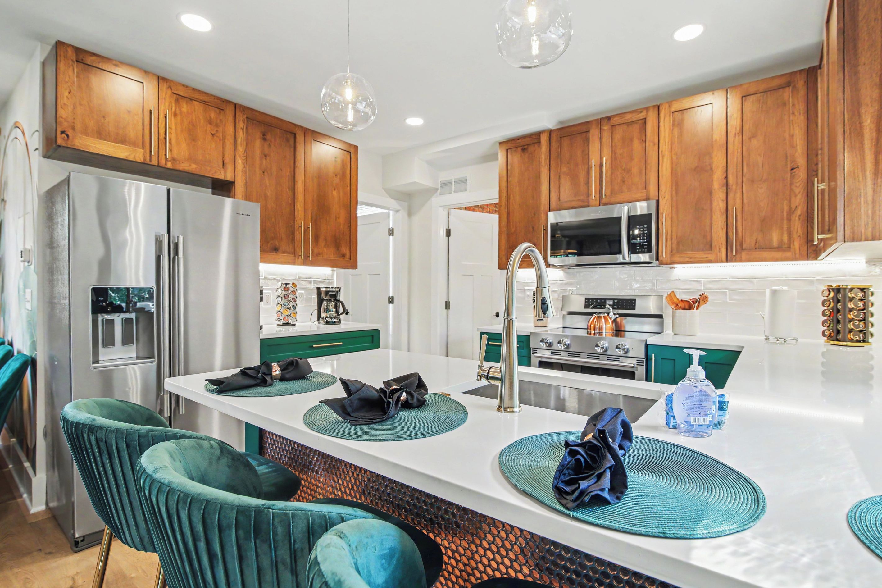 A modern kitchen with wooden cabinets, stainless steel appliances, and a central island with seating.
