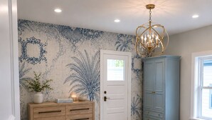 A bedroom with a bed, a dresser, a wardrobe, a chandelier, and a door with a window. - #1 Location I Fully Rebuilt 2026 I .9 Miles to Stadium/2.5 Blocks Downtown (Ann Arbor)