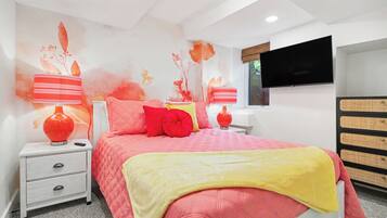 A bedroom with a bed, nightstands, a TV, and a dresser.