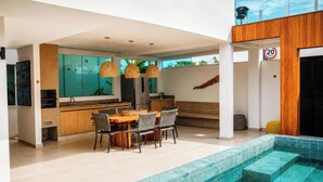 Une cuisine moderne avec un coin repas, une piscine et un panneau indiquant la limite de vitesse.