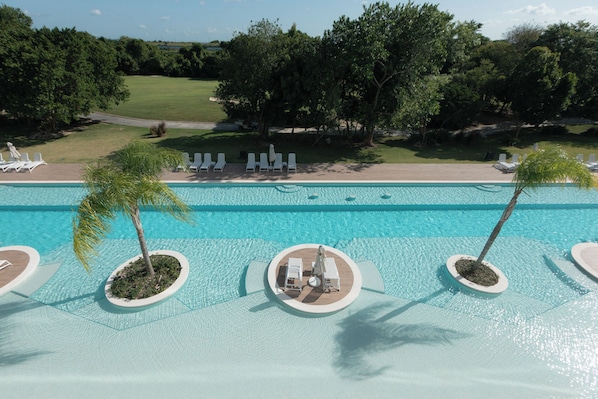 Ein Pool mit Liegestühlen und Palmen.
