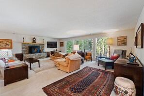 A living room with a fireplace, sofas, a coffee table, and a rug.