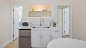 Una kitchenette compacta con microondas, tostadora, pileta y lavavajillas.