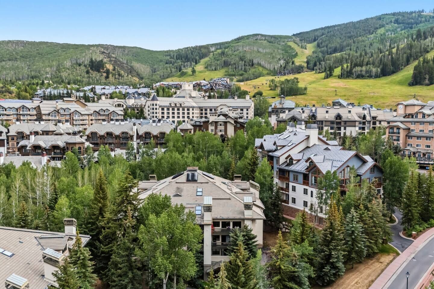 A resort with multiple buildings surrounded by trees and hills.