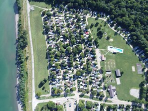 An aerial view of a residential area with houses, a swimming pool, and a tennis court.