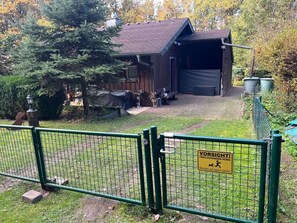 A fenced area with a wooden building, a bench, and a sign warning of a running dog. - Climate-Friendly Vacation Home in the Eifel – Near the Nürburgring & the Ahr Wine Region (Lind)