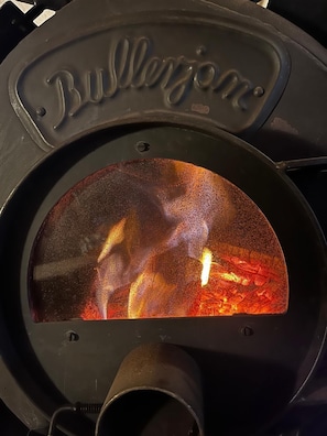 A fireplace with a glass front displaying a fire. - Climate-Friendly Vacation Home in the Eifel – Near the Nürburgring & the Ahr Wine Region (Lind)