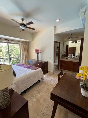 A bedroom with a bed, a dresser, a nightstand, a desk, a chair, a ceiling fan, and a window with curtains. - Beautiful apartment in the Zona Romantica, just two blocks from the beach! (Emiliano Zapata neighborhood, Puerto Vallarta)
