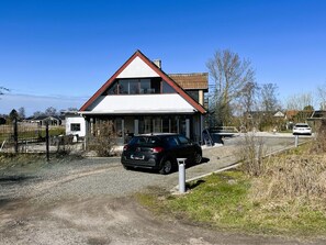 Una casa residenziale con tetto spiovente, un garage e un vialetto che porta a un'auto parcheggiata.