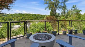 Ein Balkon mit Feuerschale, Sitzgelegenheiten und Topfpflanzen.