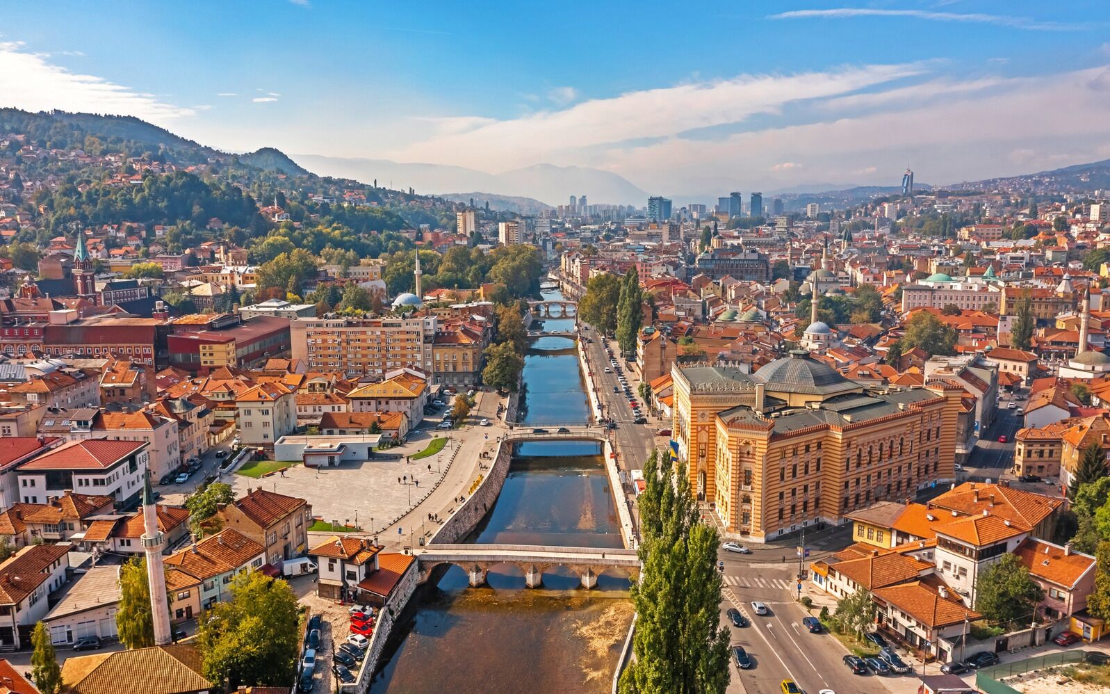 Une vue urbaine comprenant une rivière, des bâtiments historiques et un pont.