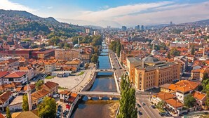 Une vue urbaine comprenant une rivière, des bâtiments historiques et un pont.