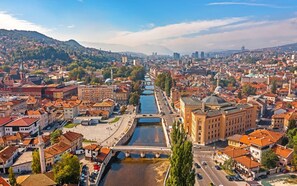 Un paisaje urbano con un río, edificios históricos y un puente.