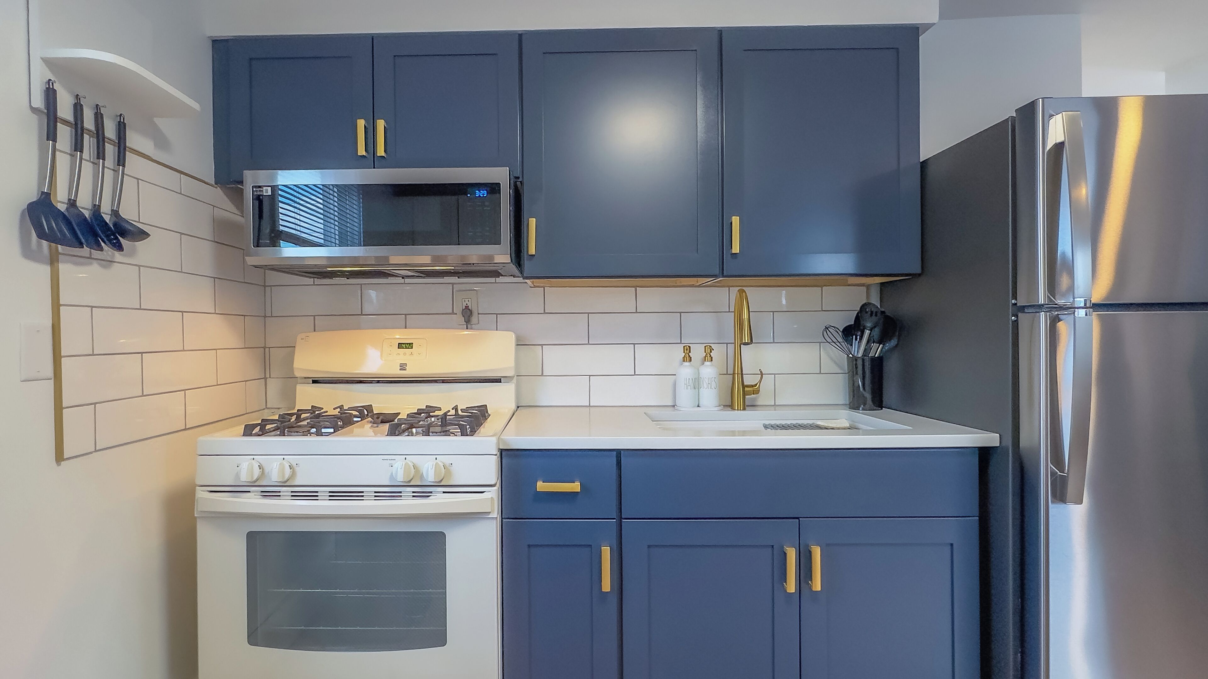 Una cocina equipada con estufa, microondas, lavaplatos y refrigerador.