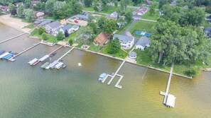 Vista aérea de una propiedad frente al lago con muelles, barcos y casas.