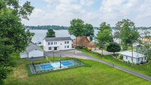 Zona residencial con cancha de tenis, casas y vista al lago.