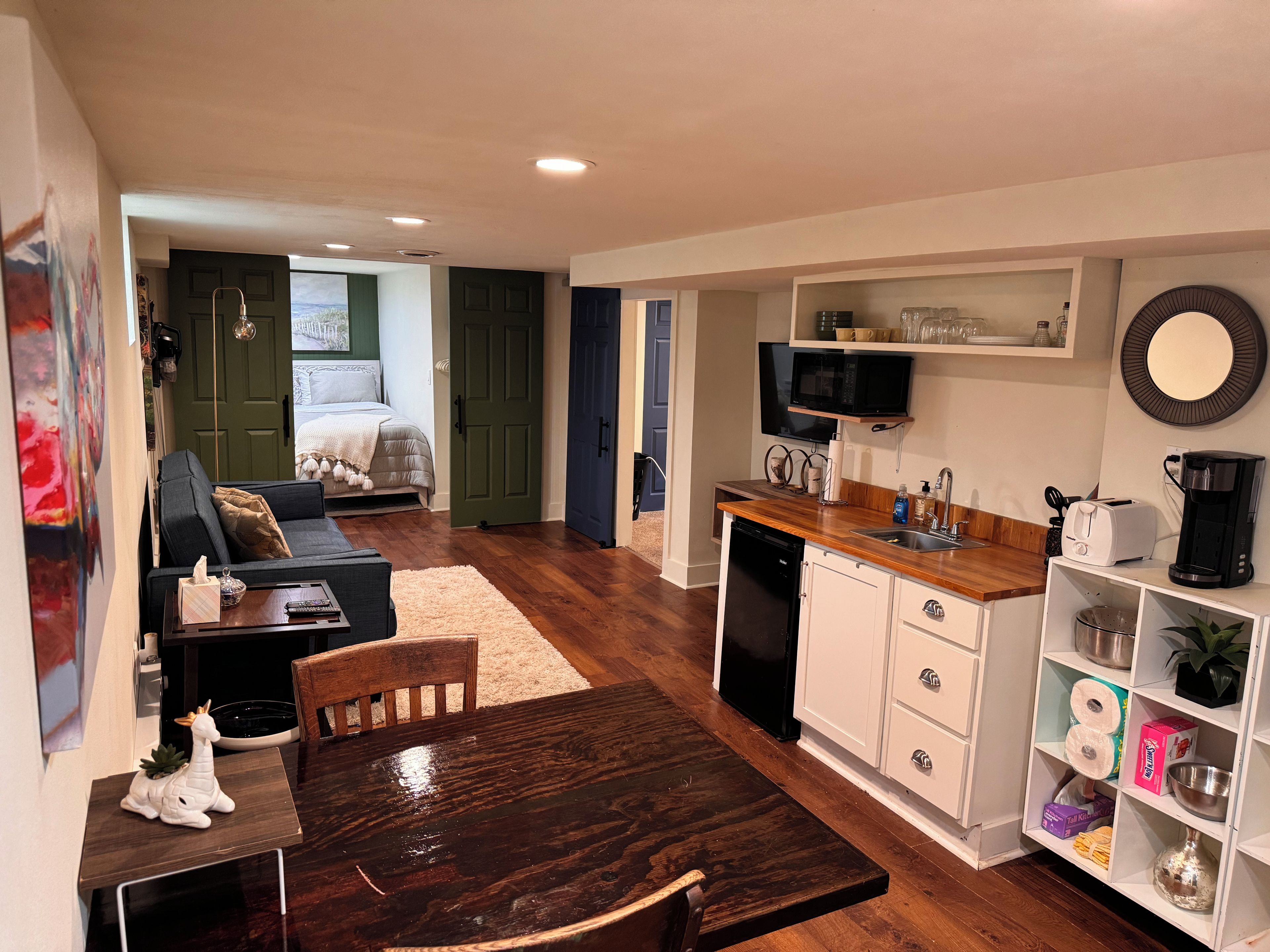 A compact living space with a kitchenette, a dining area, and a bedroom.