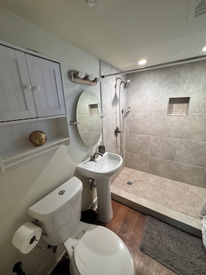 A bathroom with a toilet, sink, shower, and tiled walls. - Two Bedroom near all Milwaukee Hot Spots!! (Milwaukee)