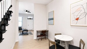 Ein modernes Interieur mit Treppe, Essbereich und Kunstwerken.