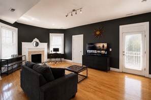 Un salon avec une cheminée, un téléviseur et un canapé.
