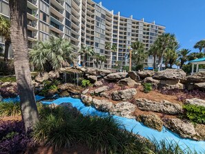 A hotel with a pool area featuring a rock waterfall and tropical landscaping. - NEW to Rentals, Completely Upgraded, Desirable location 2nd floor Villa (Panama City Beach)