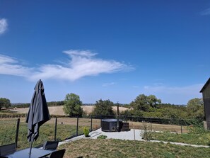 A fenced outdoor area with a table and chairs, a small structure, and a clear sky. - Fabulous house in the charming countryside of Bussières w/hot tub. Pet-friendly! (Bussières)