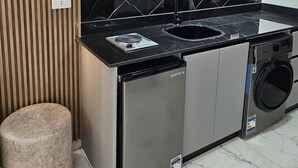A modern kitchen with a built-in stove, sink, and dishwasher. - Sasha Collection at Stone Heights -AC, Pool & Secure (Hurghada)