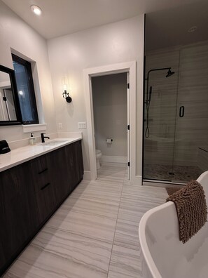 A modern bathroom with a large bathtub, a separate shower area, and a vanity with a mirror. - Beautiful 4-bedroom home in scenic Ouray, ideal for families and groups (Ouray)