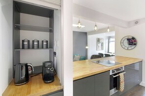 A kitchenette with a coffee maker, a Bosch electric kettle, and storage containers. - 4BR Spacious Home | Garden & Parking | Long Term (Hertfordshire)
