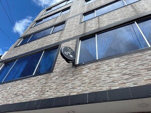 A multi-story building with a stone facade, large windows, and a sign indicating a hotel. - Apartment YKI Downtown Bogota (Bogotá)