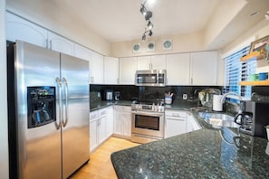 A modern kitchen with stainless steel appliances, white cabinetry, granite countertops, and a built-in oven. - Scottsdale Retreat: Pool & Sauna (Scottsdale)