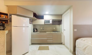 A compact kitchen with a refrigerator, microwave, and stove. - Practical Studio by the Seafront in Maceio Ete0304 (Maceió)