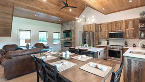 A spacious kitchen with wooden cabinets, a large island, and modern appliances. - Luxury Barndominium w/ Hot Tub, Wifi & Trout Fishing (Franklin)