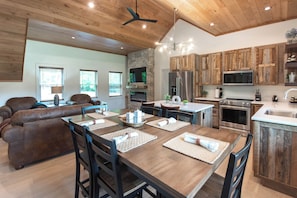 A spacious kitchen with wooden cabinets, a large island, and modern appliances.