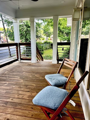 A wooden deck with two wooden chairs and a white railing. - 3-bedroom house in charming Atlanta with cool AC comfort (Atlanta)