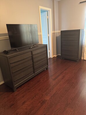 Ein Zimmer mit einem Holzschrank, einem Fernseher und einer Tür.
