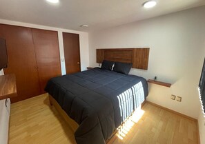 A bedroom with a bed, wooden wardrobe, bedside table, and a nightstand. - APARTMENT IN CDMX, CLOSE TO WTC (Ciudad de México)