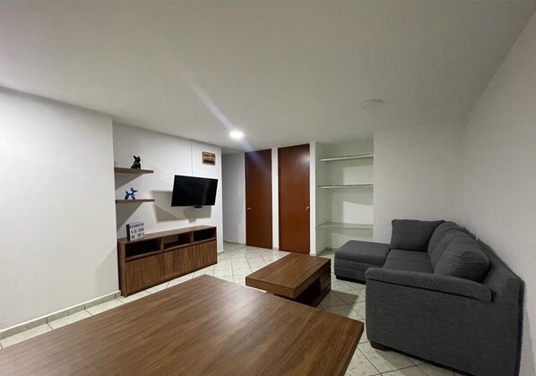 A living room with a sofa, coffee table, TV, and a cabinet. - APARTMENT IN CDMX, CLOSE TO WTC (Ciudad de México)