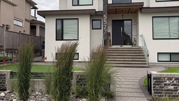 Un bâtiment moderne à deux étages, doté d’un toit plat, de grandes fenêtres et d’un numéro de maison bien visible.
