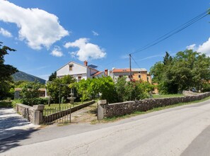 Un barrio residencial con casas, un muro de piedra y cielo despejado.